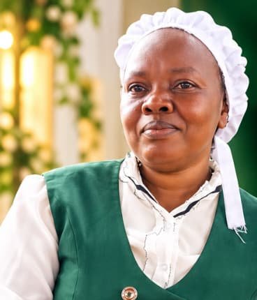 Emmy Ketitui in her catering uniform serving food