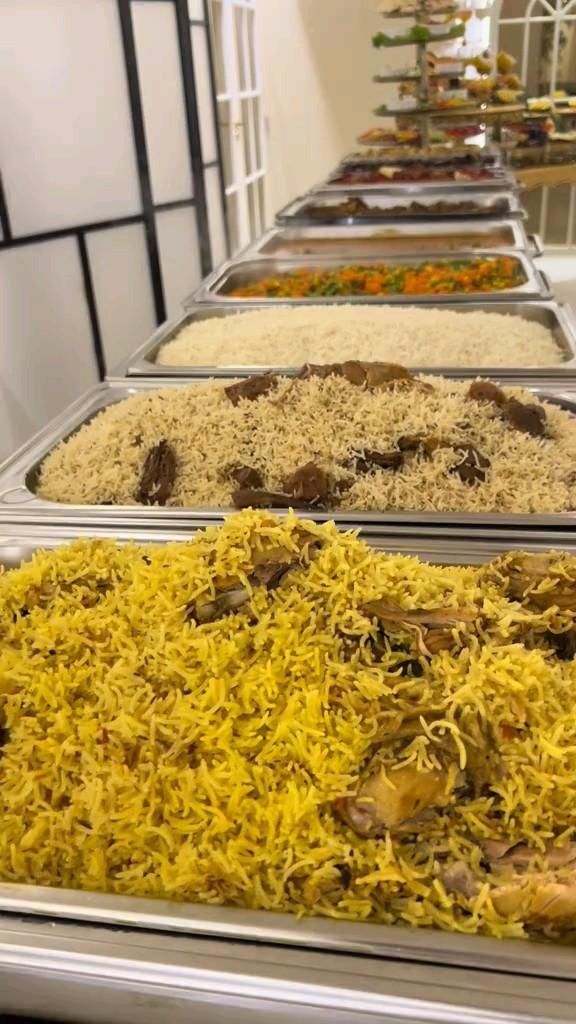 Long buffet line of rice dishes in chafing trays